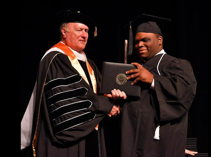 President Giles with 2019 graduate Derique Simon