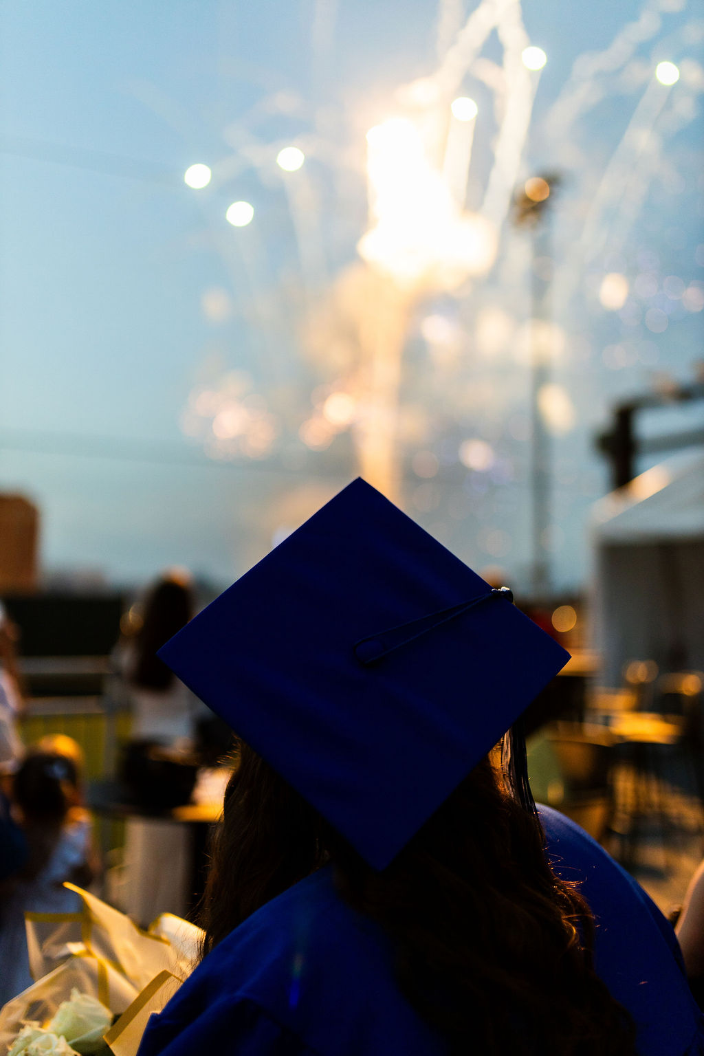 An SCC graduate watches fireworks after commencement.